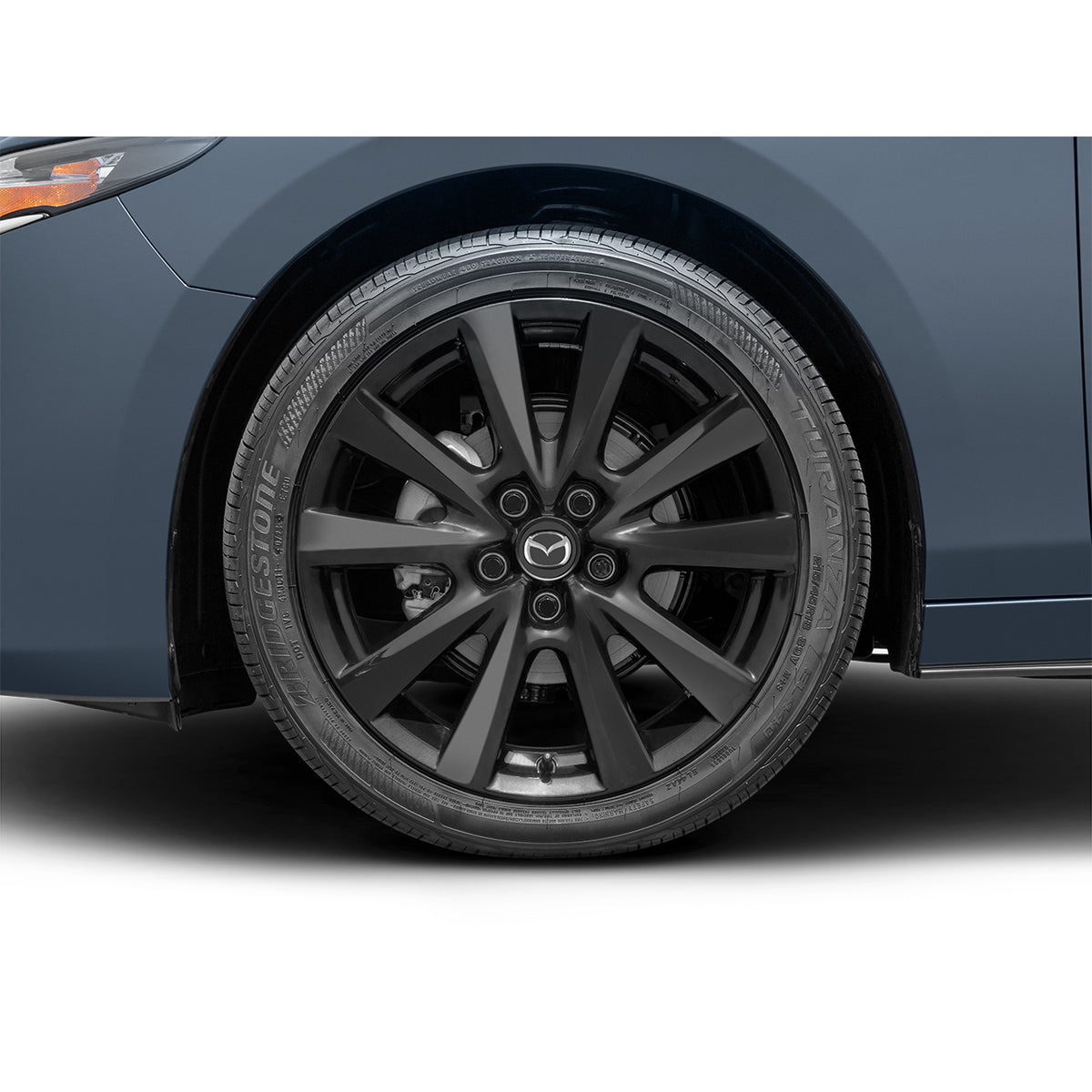 Close-up of a car wheel with a visible brand logo on a white background