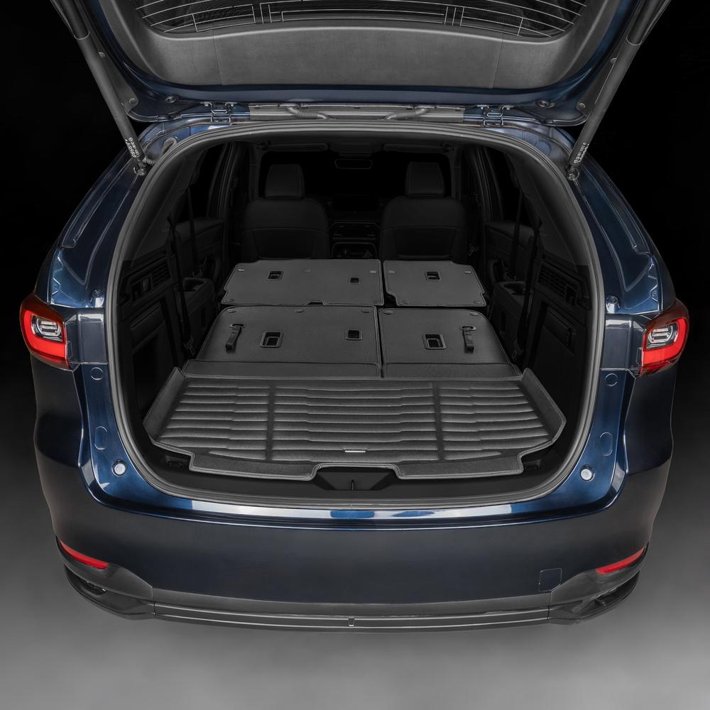 Open trunk of a car with folded cargo mats on a dark background