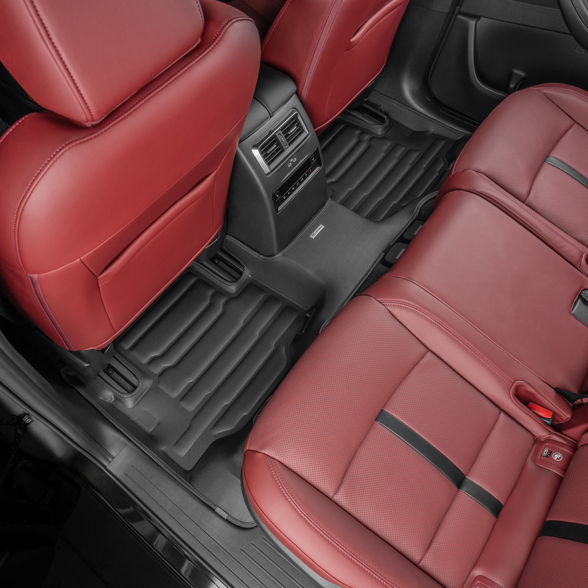 Red car interior with leather seats and black floor mats.