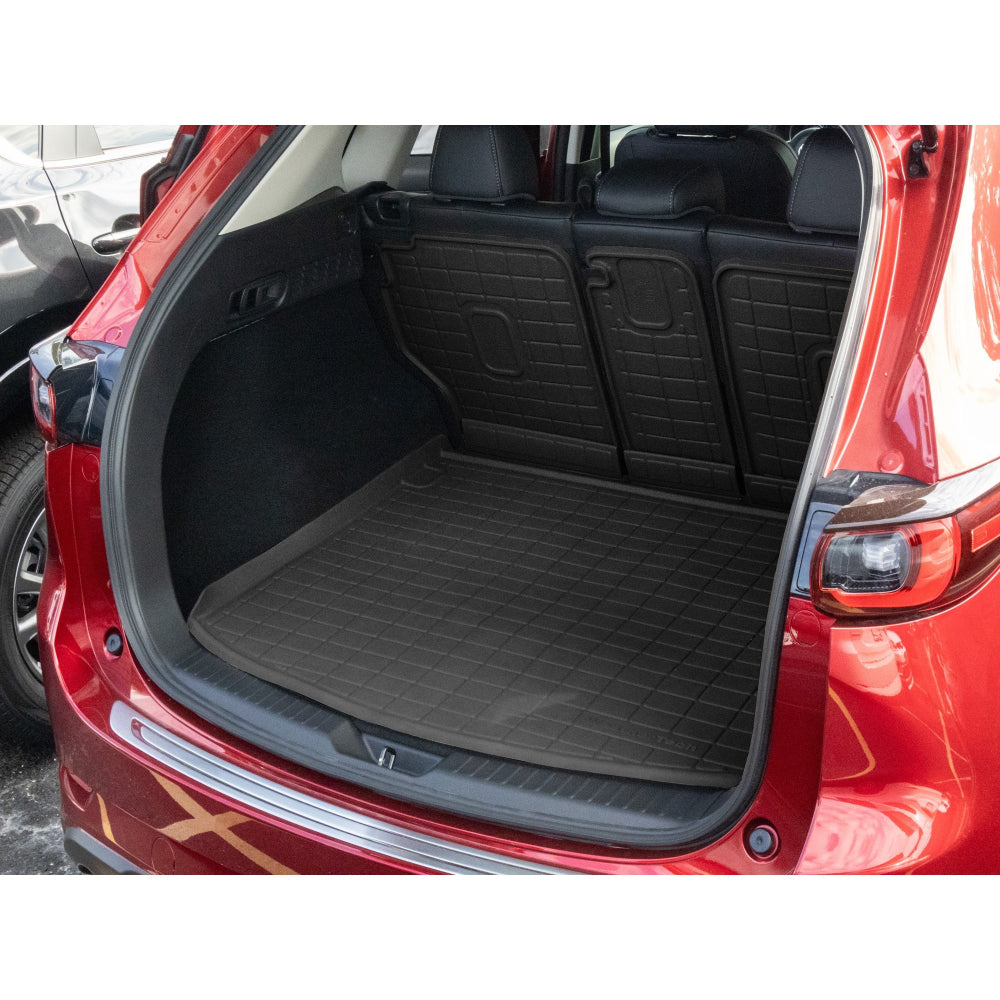 Car trunk with a black cargo mat on a red car
